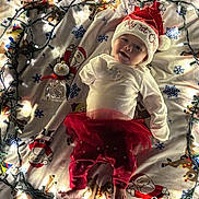 Billie Jean joined the competition — help win amazing prizes! baby, christmas_lights, blanket, santa_hat, holiday_clothing, toddler, festive, red_pants, white_shirt, smiling, indoors, decorations, reindeer, santa_claus, toy, christmas, cute, infant, holiday_season, warm