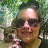 Cricket Lynn Greene is registered to the contest to win money with this photo: black_shirt, casual, cute_dog, dog, face, greenery, hand, happy, nature, necklace, outdoor, person, pet, piercing, small_dog, smile, sunglasses, sunlight, tattoo, trees