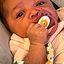 Na Mora is registered to the contest to win money with this photo: baby, pacifier, hand, face, blanket, clothing, infant, closeup, cute, child, portrait, skin, eyes, mouth, fingers, fabric, pattern, comfort, young, resting