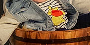 Sacha a rejoint le concours — aidez-le/la à gagner de superbes lots ! baby, child, smiling, face, denim_jacket, striped_shirt, cartoon_character, wooden_bucket, sunflowers, flowers, happy, portrait, indoor, cute, sitting, clothing, person, head, bright_eyes, rustic