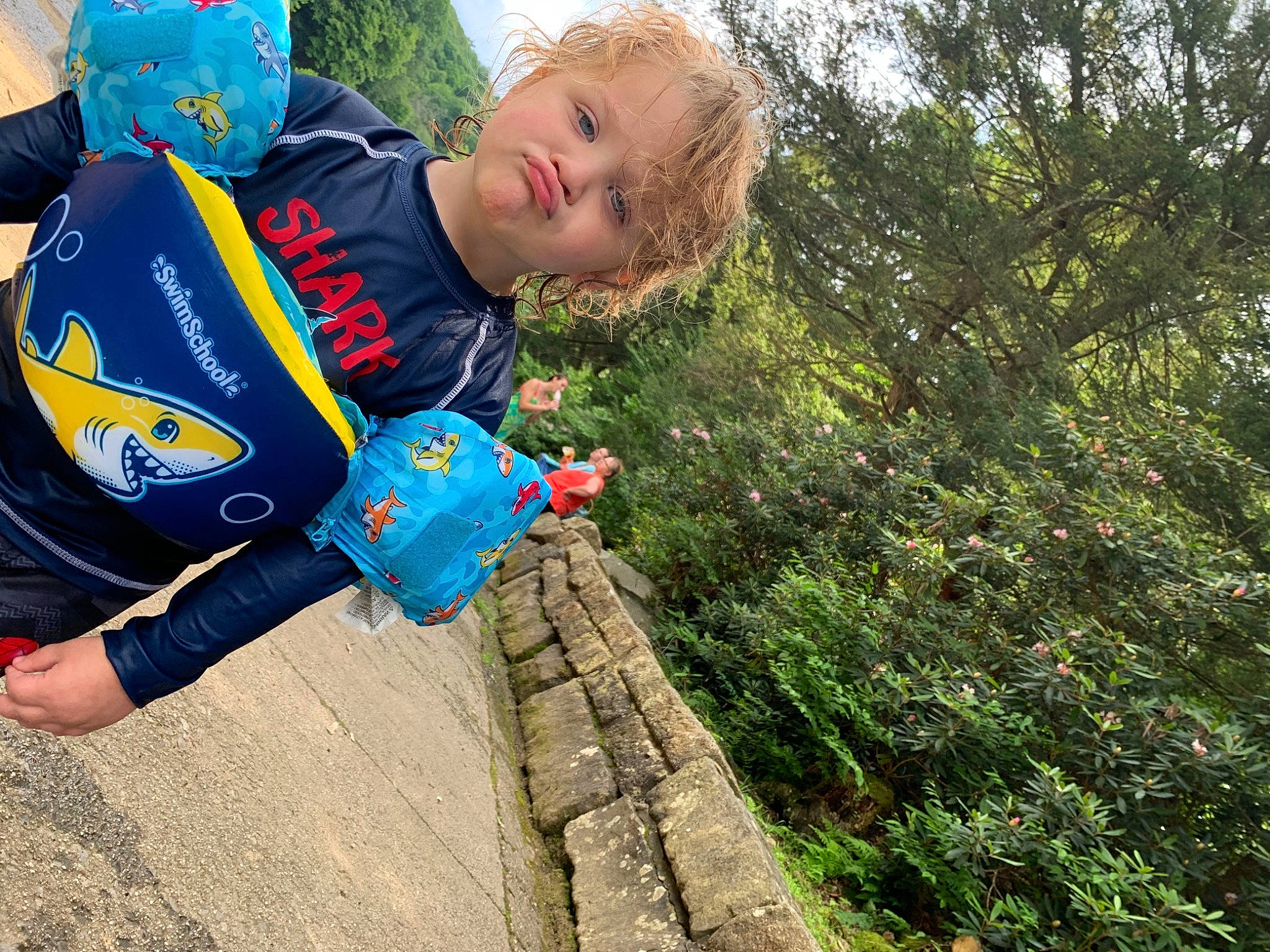 Dwayne is registered to the contest to win money with this photo: adventure, child, electric_blue, face, fun, grass, happy, landscape, leisure, people_in_nature, person, personal_protective_equipment, plant, recreation, shrub, sitting, sky, soil, t_shirt, toddler