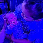 Xzavion is registered to the contest to win money with this photo: child, baby, newborn, pajamas, holding, family, indoor, couch, hand, face, person, love, care, sibling, comfort, toddler, infant, closeup, portrait, purple_light