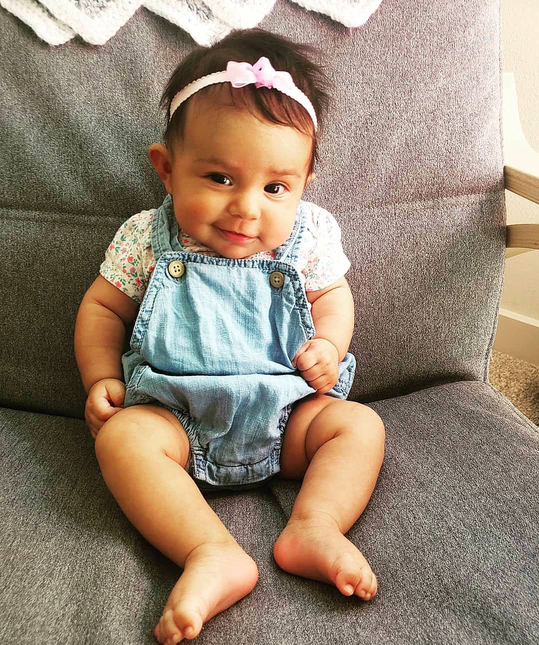 Noelia is registered to the contest to win money with this photo: baby, baby_products, baby_toddler_clothing, cheek, child, cool, dress, face, footwear, hair_accessory, head, headgear, leg, person, pink, product, sitting, skin, sleeve, smile