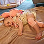 baby, infant, plush_toy, blanket, carpet, indoor, soft_toy, cute, child, leg_warmers, clothing, foot, hand, person, relaxing, floor, home, comfort, playful, expression