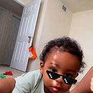 Kamaz joined the competition — help win amazing prizes! child, baby, toddler, crawling, sticker_sunglasses, onesie, carpet, open_door, door, indoor, room, face, curly_hair, hand, leg, sock, toy, selfie_thumbnail, screenshot_ui, casual_photography