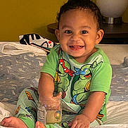 Kamaz joined the competition — help win amazing prizes! toddler, child, smiling, green_pajamas, bed, jar, hand, feet, lamp, table, blanket, room, happy, indoor, cute, messy, playful, person, pajamas, toy