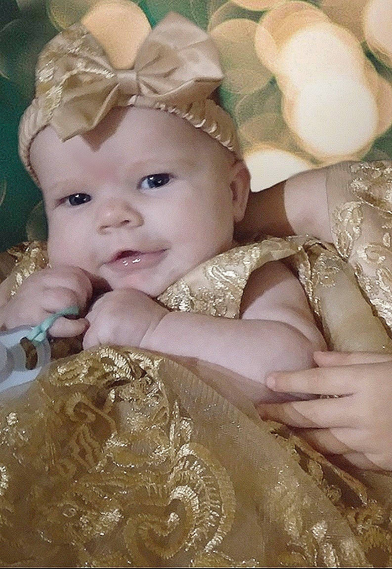 Zaria is registered to the contest to win money with this photo: baby, baby_toddler_clothing, bridal_accessory, cap, child, dress, embellishment, eye, flash_photography, happy, headband, headgear, headpiece, iris, jewellery, nail, necklace, person, skin, textile