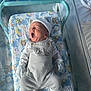 Ivar is registered to the contest to win money with this photo: newborn, baby, yawning, hospital_bassinet, blanket, mittens, hat, overalls, infant, sleepwear, bed, person, cute, resting, indoors, child, clothing, comfort, soft, portrait