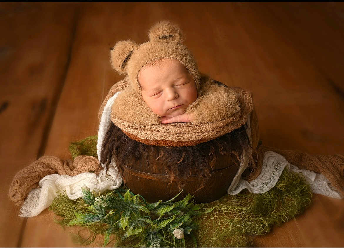 Ivar is registered to the contest to win money with this photo: newborn, baby, sleeping, bear_hat, wooden_bowl, blanket, soft_texture, greenery, portrait, cozy, cute, infant, fuzzy, resting, warm_colors, studio_photo, child, adorable, head, hands