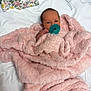newborn, baby, pacifier, blanket, pink, fluffy, infant, wrapped, lying_down, white_background, floral_cloth, cute, small, hand, face, head, soft_texture, cozy, resting, indoors