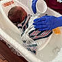 newborn, baby, hospital, bath, gloves, nurse, tub, blanket, water, infant, care, medical, person, healthcare, wrapped, wooden_floor, plastic, gentle, cleaning, swaddled