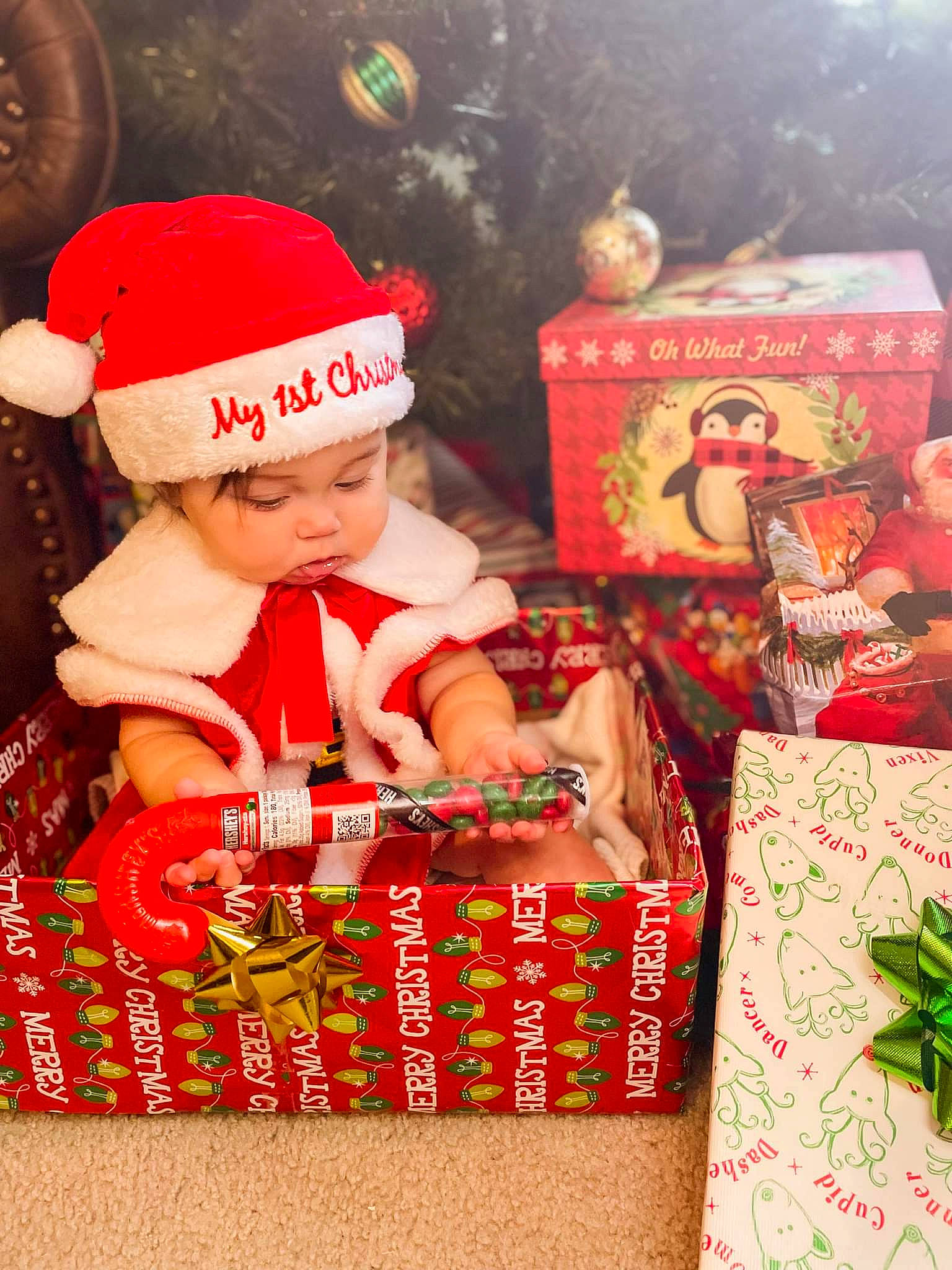 Emery is registered to the contest to win money with this photo: baby, baby_toddler_clothing, beanie, box, cap, carmine, child, christmas, christmas_decoration, christmas_eve, christmas_ornament, event, happy, headwear, holiday, knit_cap, ornament, person, sweetness, toddler