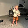 Carmello joined the competition — help win amazing prizes! toddler, child, barefoot, smile, sweater, shorts, carpet, living_room, lamp, sofa, window, blinds, cushion, floor, person, indoor, home, furniture, cute, happy