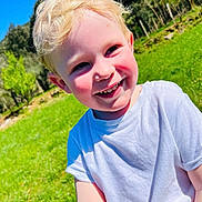 Tom participe au concours pour gagner de l'argent avec cette photo : blonde_hair, blue_sky, boy, casual_clothing, child, daylight, grass, grass_field, greenery, happy, nature, outdoor, person, portrait, rosy_cheeks, smiling, sunny, trees, white_tshirt, young