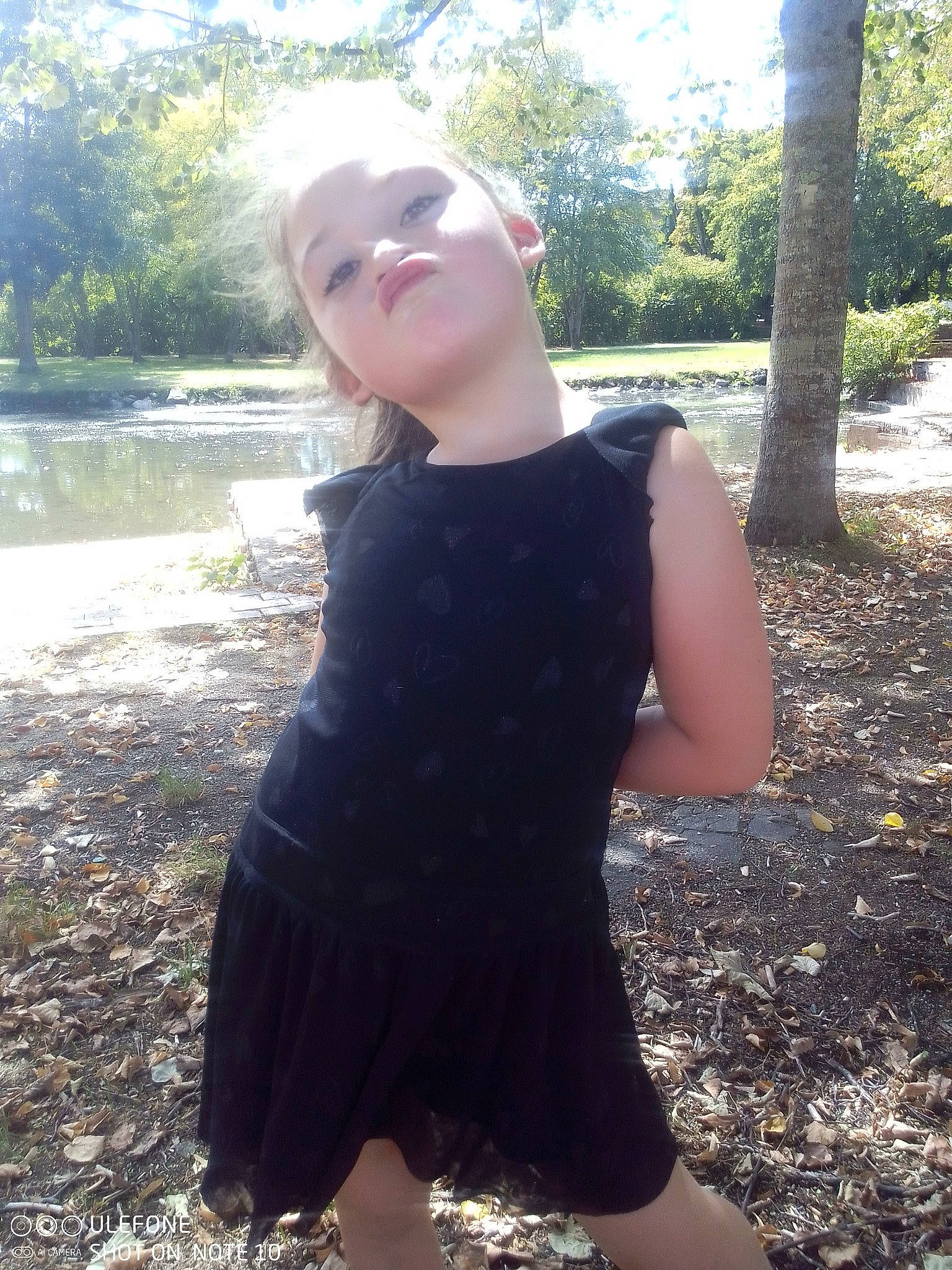 Lynne participe au concours pour gagner de l'argent avec cette photo : brown_hair, day_dress, formal_wear, grass, hair, head, long_hair, neck, one_piece_garment, pattern, people_in_nature, person, plant, shoulder, sleeve, sunlight, t_shirt, thigh, tree, trunk