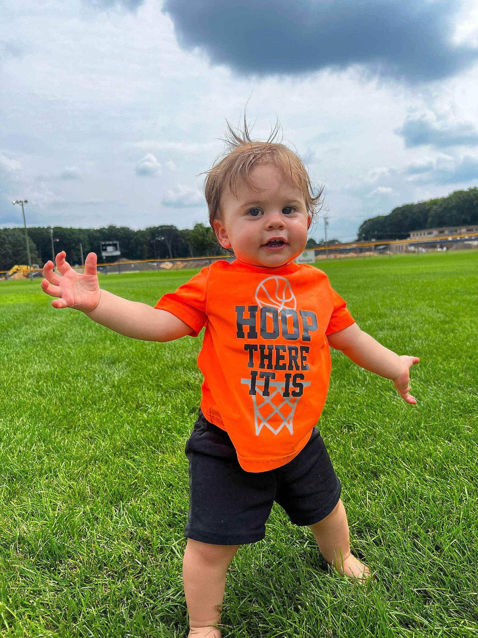 Jamison is registered to the contest to win money with this photo: baby_toddler_clothing, cloud, fun, games, gesture, grass, grass_family, grassland, happy, lawn, leisure, meadow, people_in_nature, person, prairie, recreation, shorts, sky, t_shirt, toddler