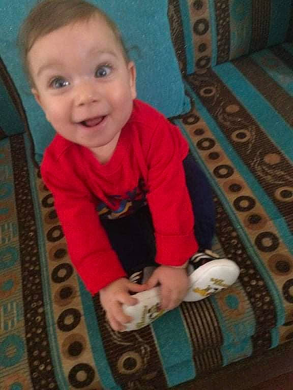 Youssef participe au concours pour gagner de l'argent avec cette photo : arm, baby, baby_toddler_clothing, blue, cheek, eye, face, finger, floor, flooring, head, linens, nose, pattern, person, rectangle, sleeve, smile, t_shirt, toddler