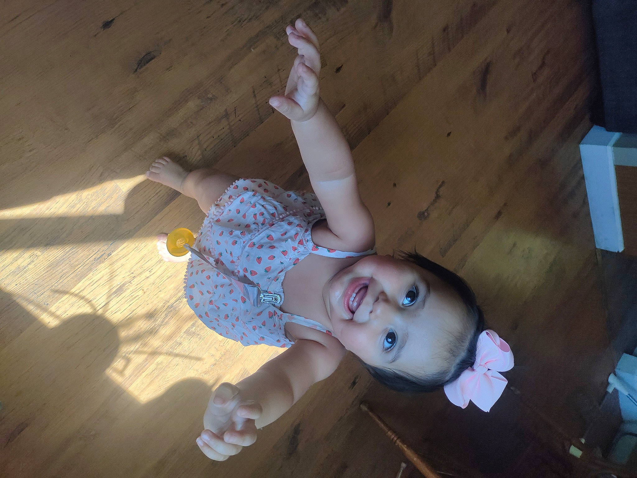 Christine is registered to the contest to win money with this photo: child, elbow, flooring, fun, gesture, happy, hardwood, human_leg, joy, knee, leisure, person, sitting, smile, toddler, vacation, wood