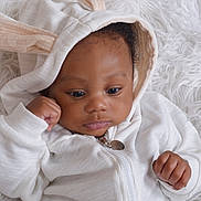 Josiah is registered to the contest to win money with this photo: baby, infant, child, hoodie, white_clothing, bunny_ears, cute, portrait, face, skin, hand, fist, lying_down, soft_texture, blanket, cozy, sleepy, closeup, expression, adorable
