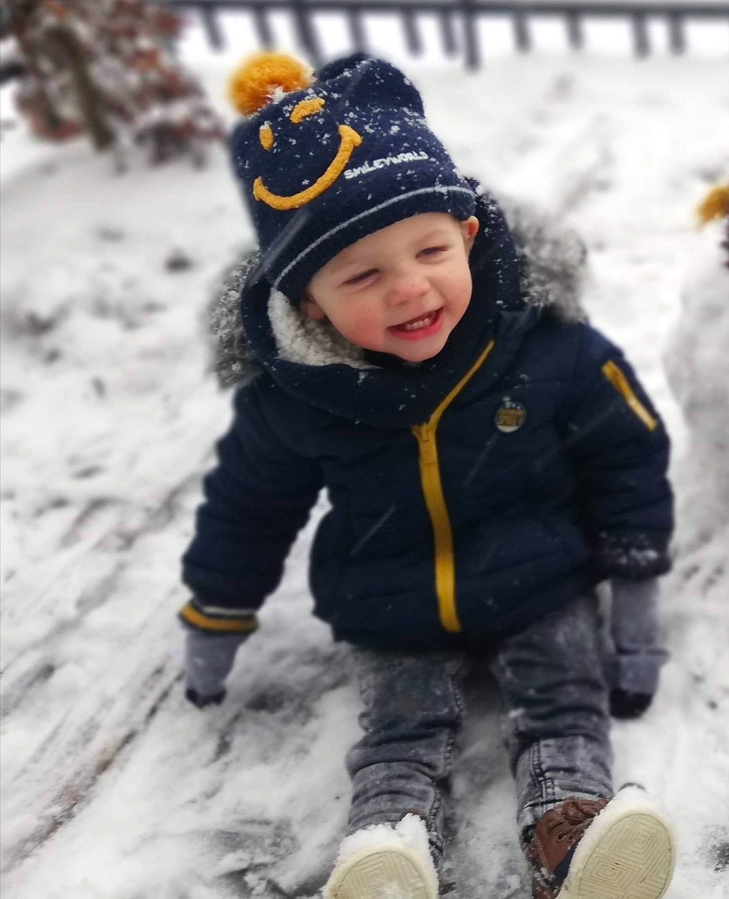 Aeden a rejoint le concours — aidez-le/la à gagner de superbes lots ! baby_toddler_clothing, beanie, cap, child, face, footwear, freezing, fun, fur, glove, happy, headwear, jacket, knit_cap, people_in_nature, person, recreation, smile, snow, toddler