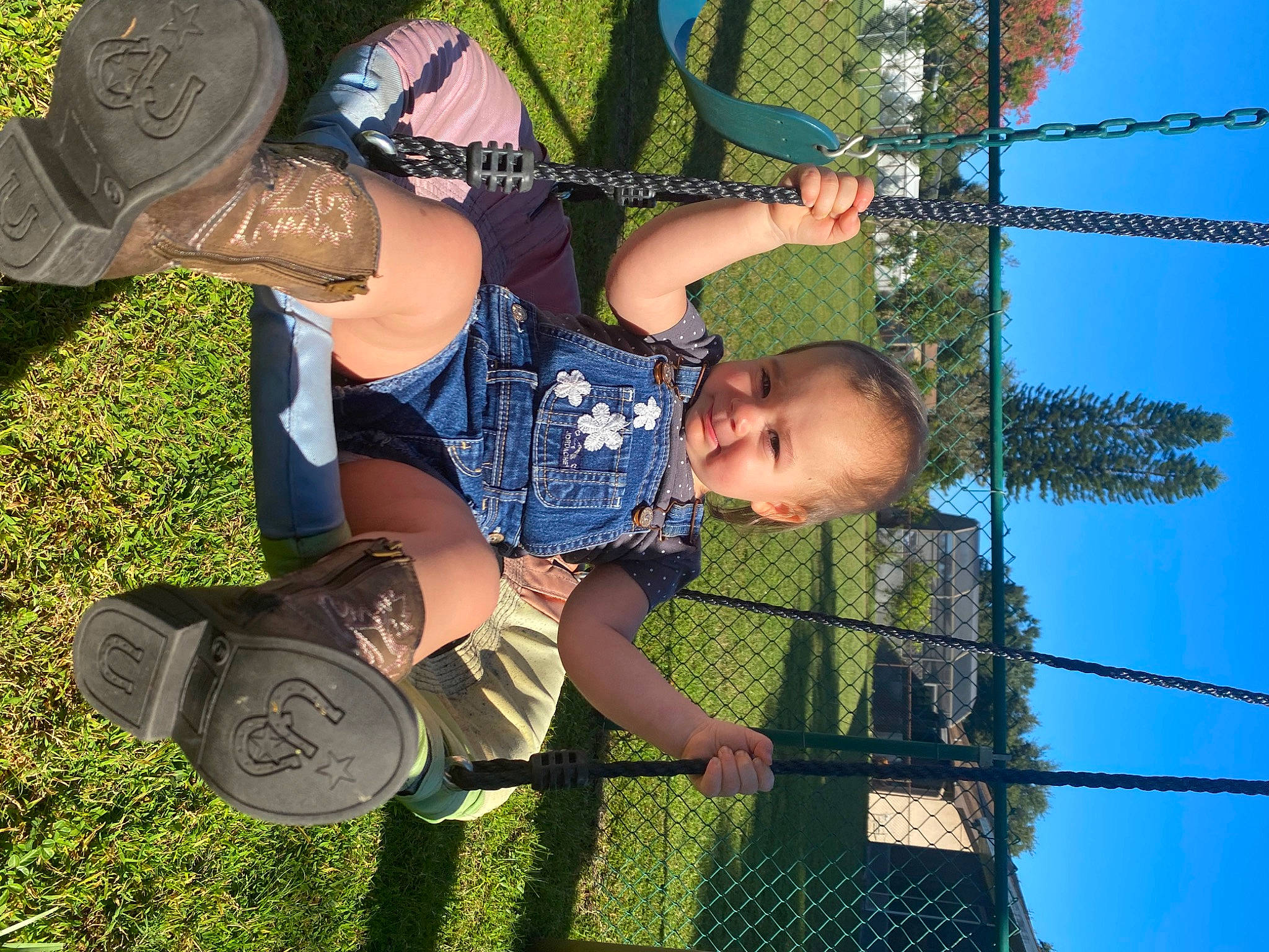 Korra is registered to the contest to win money with this photo: child, fence, fun, grass, green, happy, hat, leisure, people_in_nature, person, plant, play, playground, recreation, shorts, sky, smile, t_shirt, toddler, tree