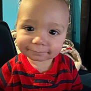 Aj joined the competition — help win amazing prizes! baby, toddler, child, infant, face, smile, eyes, cheeks, portrait, close_up, red_clothing, striped_shirt, indoor, blanket, chair, wall, happy, cute, head, expression