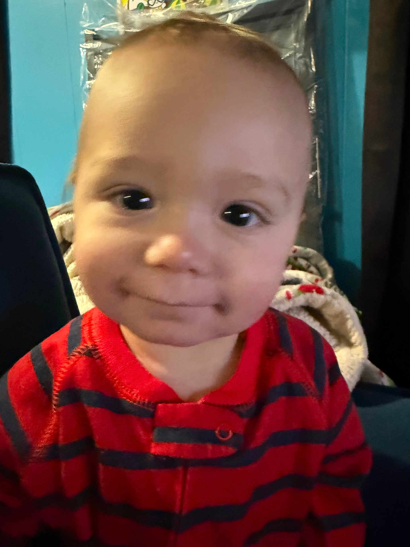 Aj joined the competition — help win amazing prizes! baby, toddler, child, infant, face, smile, eyes, cheeks, portrait, close_up, red_clothing, striped_shirt, indoor, blanket, chair, wall, happy, cute, head, expression