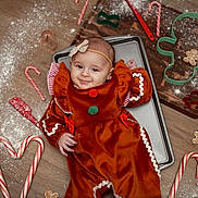 Sofia joined the competition — help win amazing prizes! baby, child, gingerbread_costume, candy_cane, cookie_cutter, flour, baking_tray, wooden_floor, holiday, christmas, smile, red, green, headband, cute, festive, playful, indoors, person, portrait