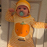Reece is registered to the contest to win money with this photo: baby, infant, pacifier, striped_clothing, yellow, white, pumpkin_design, hat, polka_dot, changing_pad, lying_down, cute, child, indoors, soft_lighting, portrait, one_person, smiling_pumpkin, baby_clothes, headwear