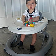 Julius Arceo joined the competition — help win amazing prizes! toddler, baby_walker, toy, indoor, child, floor_tile, white_door, curious, sitting, clothing, shoes, plastic, childrens_toy, person, footwear, expression, play, home, walker, young_child