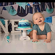 Samuel is registered to the contest to win money with this photo: baby, birthday, cake, blue, white, celebration, child, decorations, festive, floor, happy, messy, one, photography, portrait, smiling, studio, toddler, young, cute