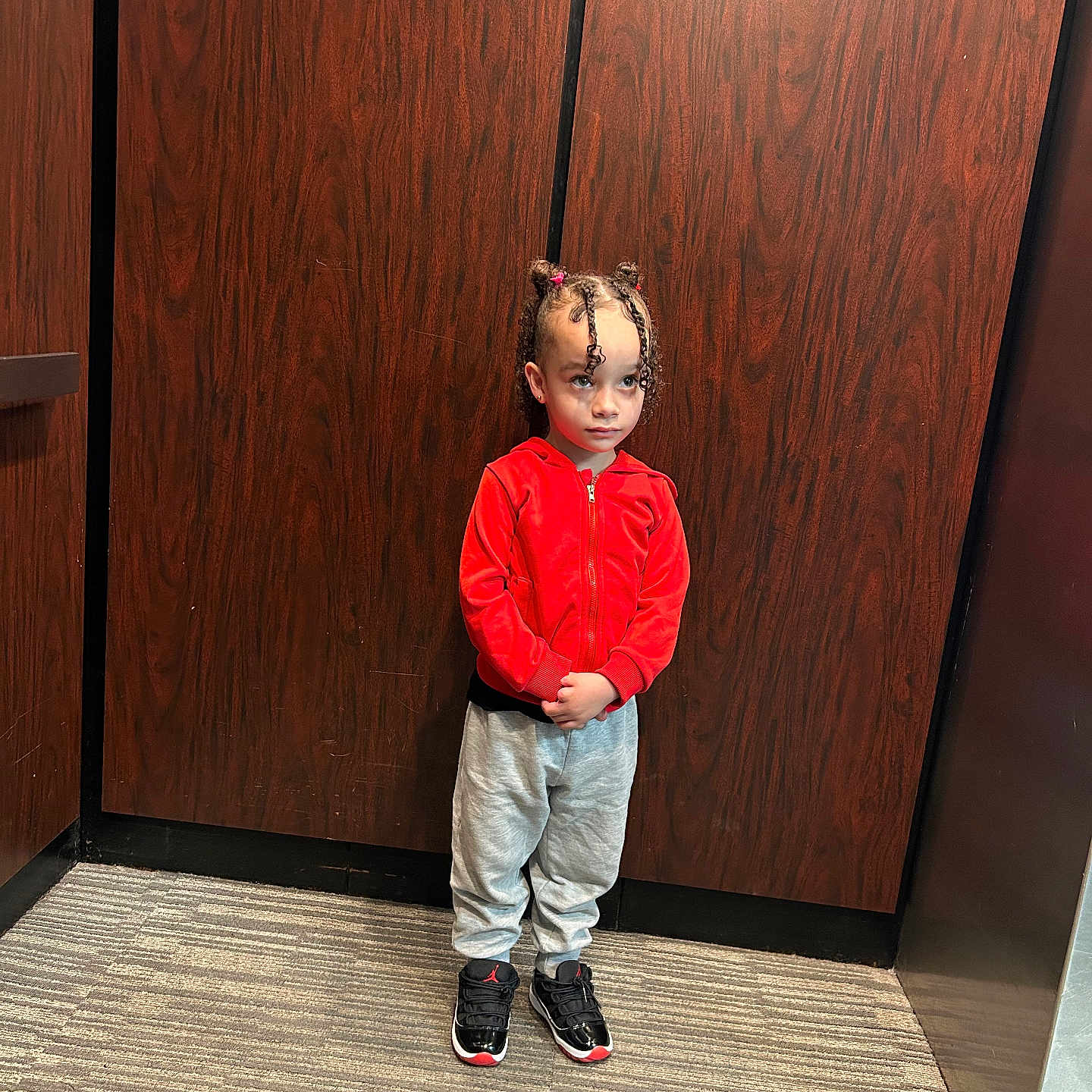 Remedy joined the competition — help win amazing prizes! black_shoes, braided_hair, carpet, casual, child, clothing, elevator, expression, feet, floor, gray_sweatpants, hairstyle, indoor, person, portrait, red_jacket, standing, wall, wooden_panel, young_child