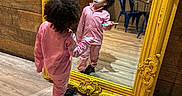 Remedy is registered to the contest to win money with this photo: cafe, casual_clothing, chairs, child, curly_hair, decor, floor, indoor, mirror, person, pink_tracksuit, pose, reflection, shadow, smiling, table, toothbrush, wooden_floor, wooden_wall, yellow_frame