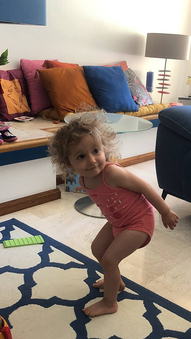 Alice a rejoint le concours — aidez-le/la à gagner de superbes lots ! azure, child, comfort, couch, floor, flooring, fun, furniture, happy, interior_design, joy, leisure, living_room, person, pillow, purple, sandal, smile, standing, thigh