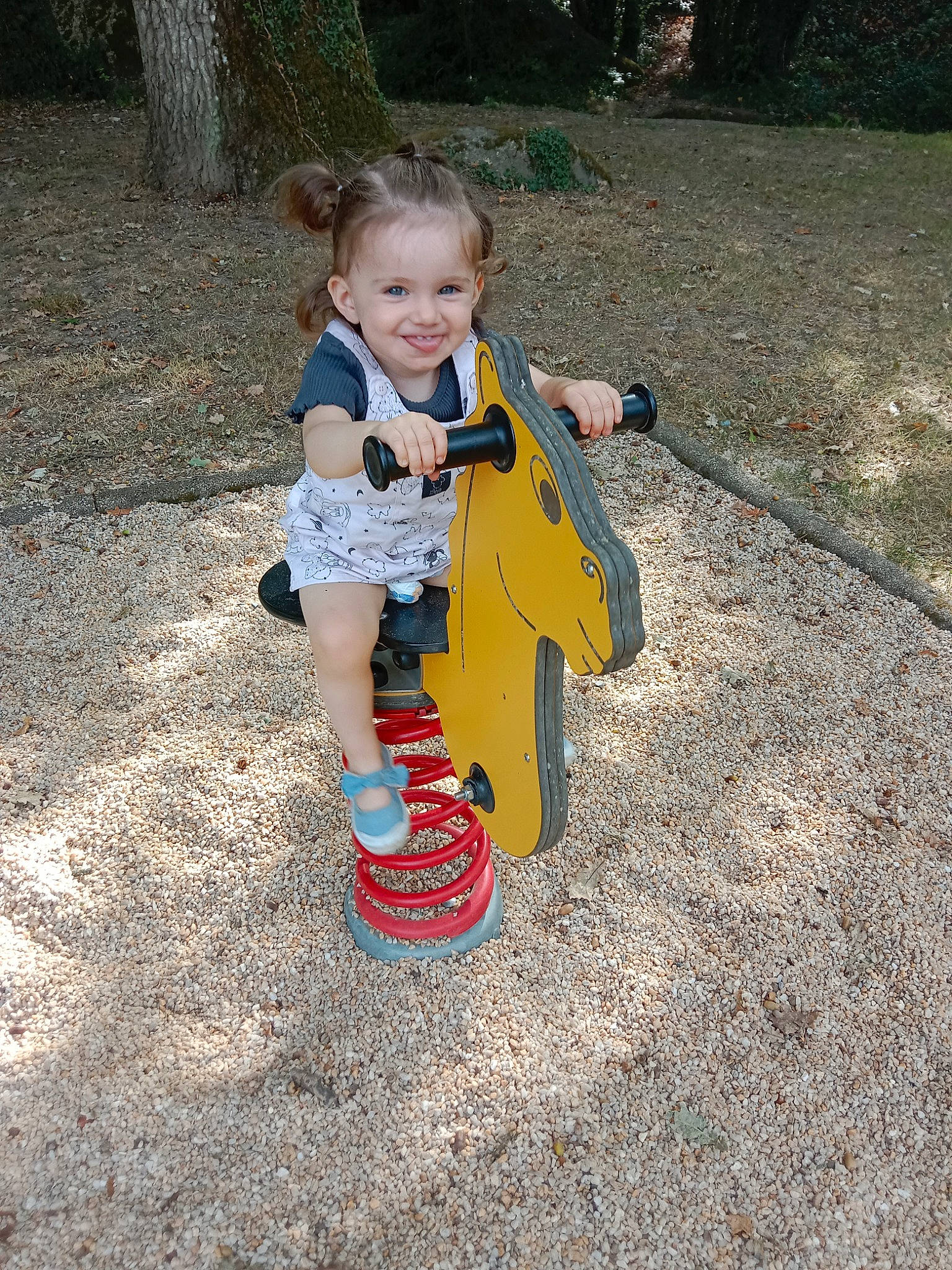Malya participe au concours pour gagner de l'argent avec cette photo : asphalt, baby_toddler_clothing, boot, child, city, fun, grass, joy, musical_instrument, outdoor_play_equipment, people_in_nature, person, plant, play, recreation, sitting, smile, sock, soil, toddler