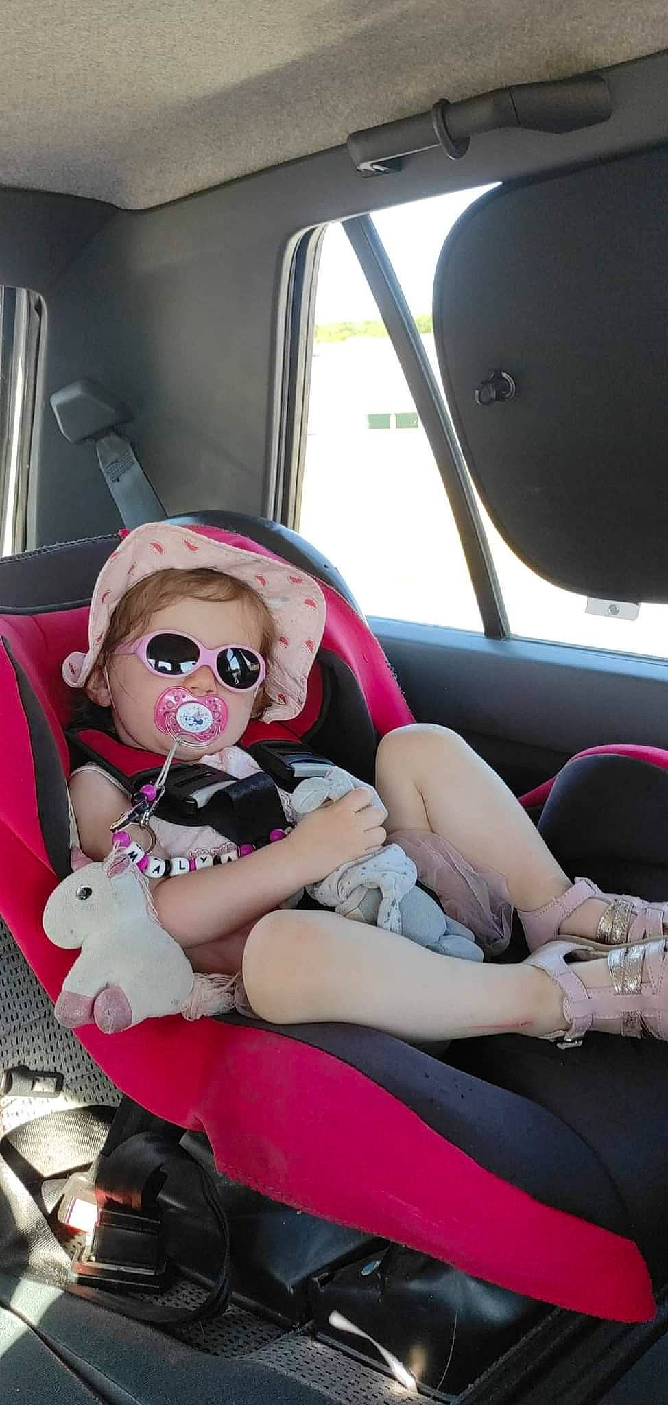 Malya a rejoint le concours — aidez-le/la à gagner de superbes lots ! auto_part, automotive_design, automotive_exterior, car, car_seat, car_seat_cover, comfort, eyewear, family_car, goggles, head_restraint, human_leg, lap, motor_vehicle, person, pink, sitting, steering_wheel, thigh, toy