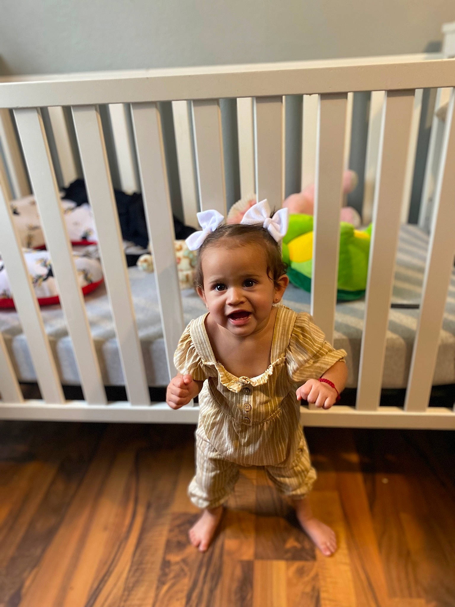 Madelyn is registered to the contest to win money with this photo: baby, baby_products, baby_safety, baby_toddler_clothing, child, comfort, cradle, design, fence, floor, flooring, happy, hardwood, infant_bed, nursery, person, smile, toddler, varnish, wood