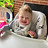 River joined the competition — help win amazing prizes! baby, bib, blanket, brick_wall, child, clothing, cute, flowers, food, greenery, happy, high_chair, messy_face, outdoor, person, plastic_chair, portrait, sandwich, smiling, table