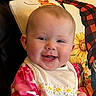 baby, bib, cheerful, child, close_up, cute, daisies, earring, face, happy, indoor, infant, person, pillow, pink_clothing, portrait, seated, smiling, sunflower, young