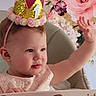 River is registered to the contest to win money with this photo: baby, birthday, celebration, child, crown, cute, dress, earring, first_birthday, floral_background, flower, gold, happy, headwear, high_chair, indoor, person, pink, portrait, raising_hand