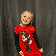Kelya a rejoint le concours — aidez-le/la à gagner de superbes lots ! child, girl, smile, red_dress, minnie_mouse, long_sleeves, standing, curtain, indoor, blonde_hair, braided_hair, happy, portrait, cute, fashion, clothing, person, posing, playful, young