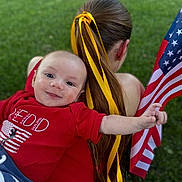 Barrett joined the competition — help win amazing prizes! baby, child, person, red_shirt, yellow_ribbon, pony_tail, american_flag, grass, outdoor, smiling, happy, holding, portrait, casual_clothing, young_child, flag, nature, summer, toddler, celebration