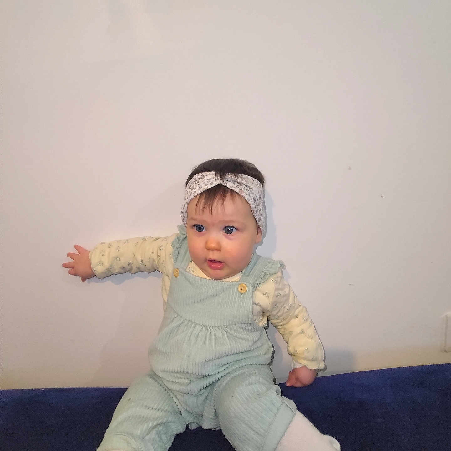Maëlla a rejoint le concours — aidez-le/la à gagner de superbes lots ! baby, beanie, bodypart, bonnet, cap, clothing, face, finger, hand, hat, head, jeans, longsleeve, pants, person, photography, portrait, sitting, sleeve, wood