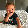 Kreedence is registered to the contest to win money with this photo: baby, bed, bedroom, casual, child, clothing, comforter, curly_hair, cute, face, hand, happy, indoor, infant, joyful, person, sitting, smiling, toddler, young_child