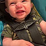 Dominic is registered to the contest to win money with this photo: baby, camouflage_clothing, car_seat, child, close_up, cute, expression, face, hand, happy, indoors, infant, person, red_button, safety, seatbelt, skin, smiling, straps, young
