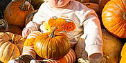 Archie is registered to the contest to win money with this photo: baby, pumpkin, autumn, outdoor, child, smiling, orange, fall, cute, clothing, striped_leggings, festive, seasonal, happy, sitting, nature, sunlight, harvest, playful, portrait