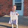Lakelyn joined the competition — help win amazing prizes! child, girl, smile, dress, tights, shoes, artwork, bunny, drawing, brick_wall, door, porch, sunlight, happy, outdoor, standing, hair, face, person, concrete
