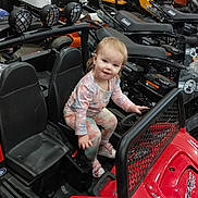 Lakelyn is registered to the contest to win money with this photo: black, child, clothing, curious, equipment, floor, footwear, handlebar, happy, indoor, lawn_mower, machine, playful, red, seat, shopping, store, toddler, toy_vehicle, yellow