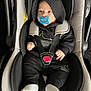 baby, car_seat, pacifier, hoodie, black_clothing, white_socks, infant, child, seat_belt, safety, cute, indoor, person, small_hands, footwear, clothing, infant_care, baby_accessory, portrait, car_interior