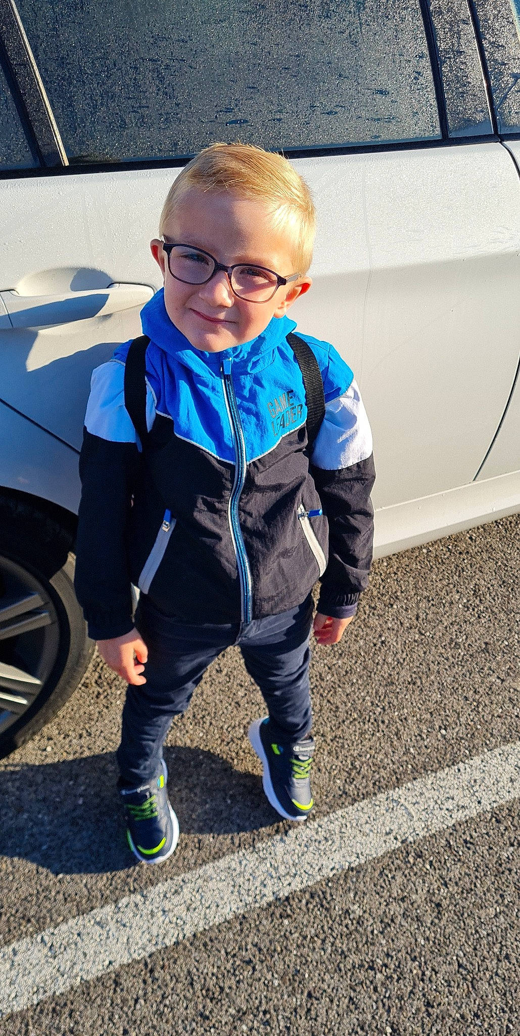 Isaac participe au concours pour gagner de l'argent avec cette photo : automotive_design, automotive_tire, car, electric_blue, eyewear, face, glasses, hood, jacket, joy, land_vehicle, motor_vehicle, person, personal_protective_equipment, shoe, sneakers, sunglasses, tire, toddler, vehicle
